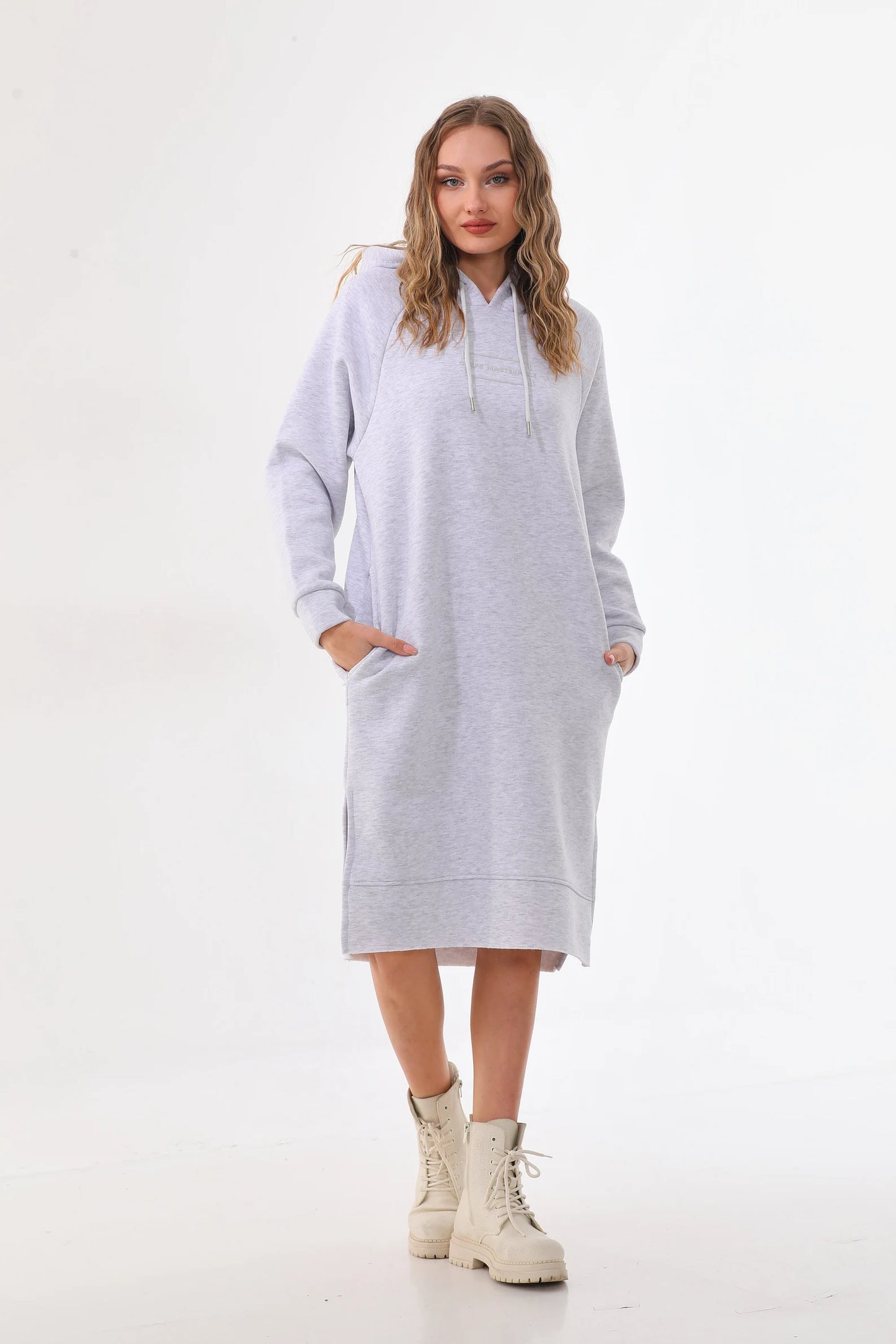 Woman wearing a light gray hoodie dress on a white background